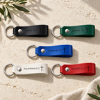 Five leather keychains in black, green, blue, white and red, each engraved with a Bible reference and cross.
