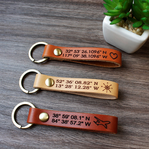 Custom full-grain leather coordinates keychain in cognac brown with laser engraved GPS location coordinates and compass symbol on front and personalized message on back with solid screw metal hardware ring.