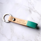 Multiple leather keychains with custom engraving, displayed on a light surface.